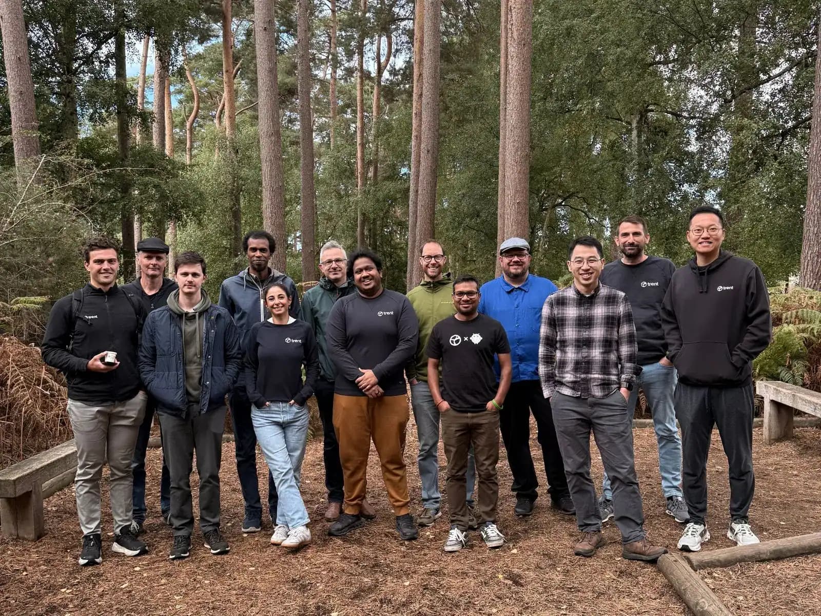 The Trent AI team, standing together outdoors among tall pine trees.